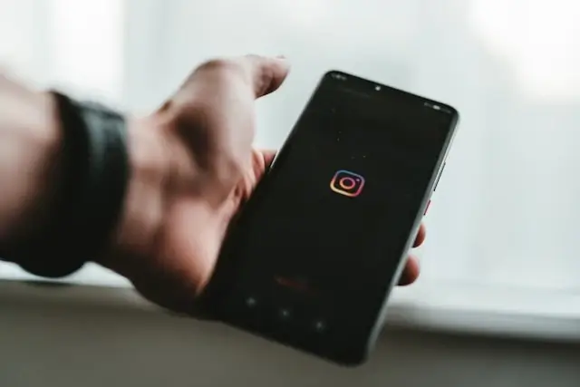 A man looking at Instagram on a smartphone.